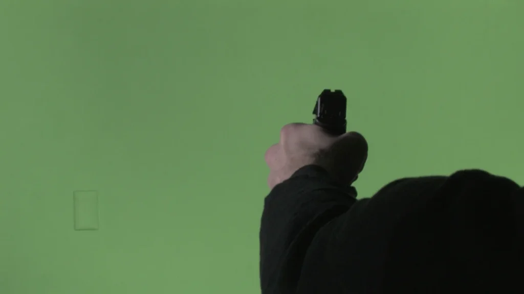 Airsoft gun from behind using a Chroma Key wall.